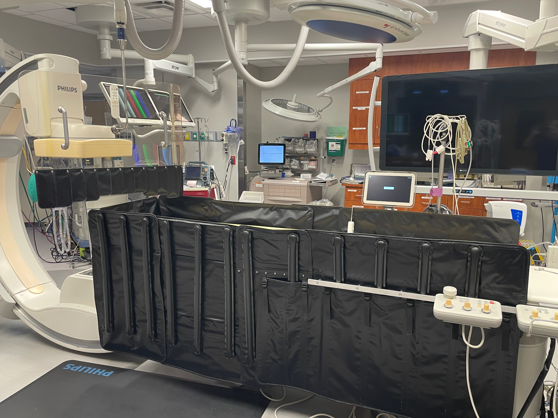 Close view of the AeroShield inflatable lower shield mounted on the procedure table, showing the segmented air bladders and tableside controller